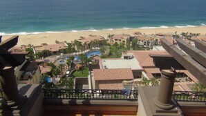 Un resort con vista a la playa, varias piscinas y un jardín bien cuidado.