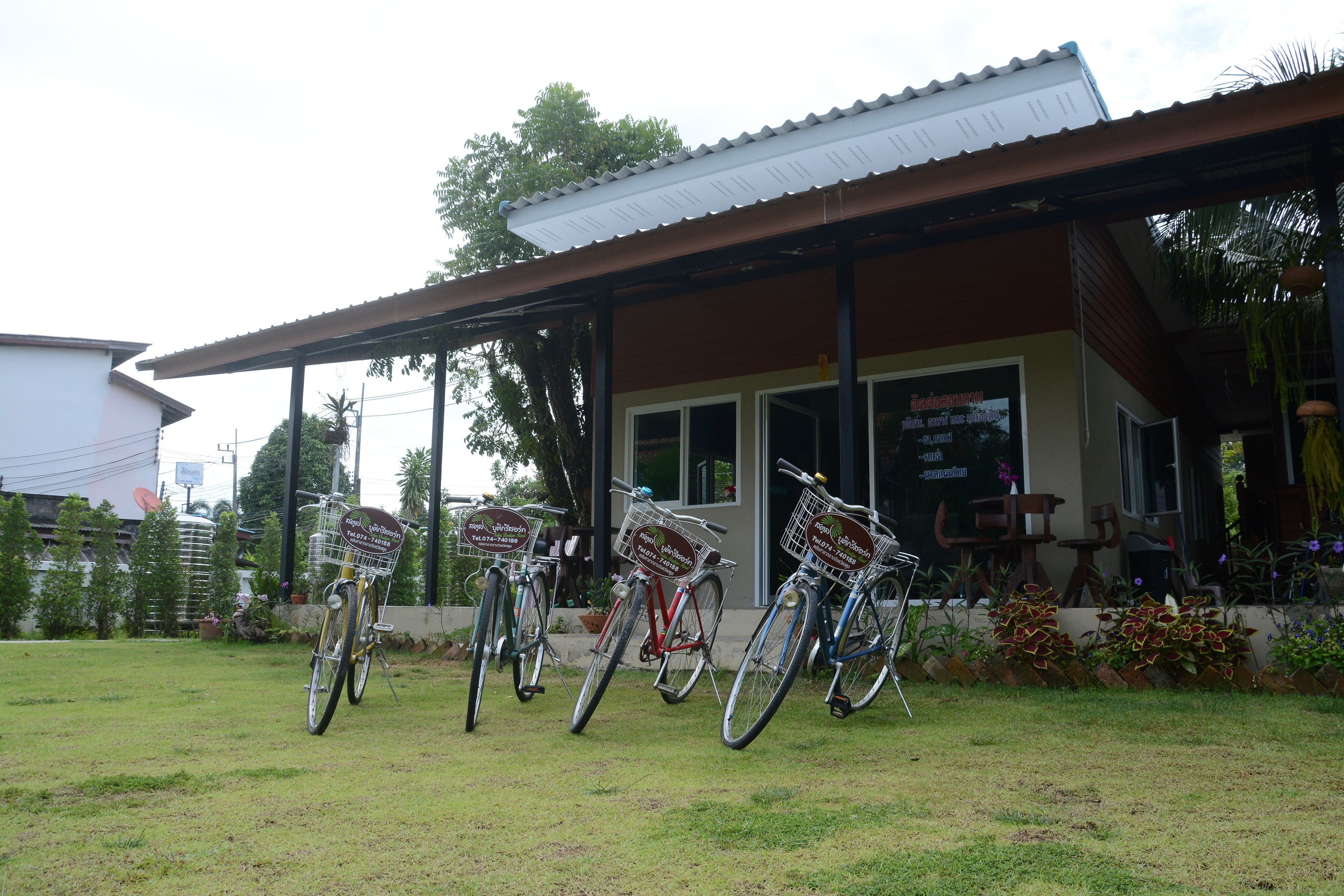 A building with a covered porch and several bicycles parked outside.