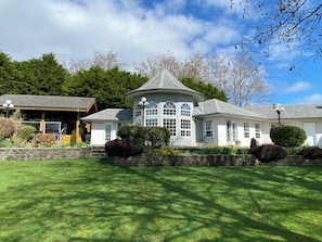 A house with a large front lawn, a garage, and a covered porch.