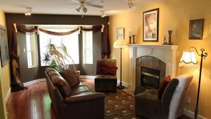 A living room with a fireplace, a sofa, a chair, and a lamp. - Selah Retreat Guesthouse B&B -  "Defining Tranquility, Beauty and Excellence!" (Sorrento)