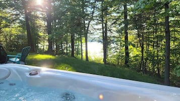 Relax in a serene forest setting, surrounded by lush greenery, with a hot tub at your fingertips.