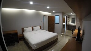 A modern bedroom with a large bed, a desk, and a mirror. - Kanith Place (Chiang Mai)