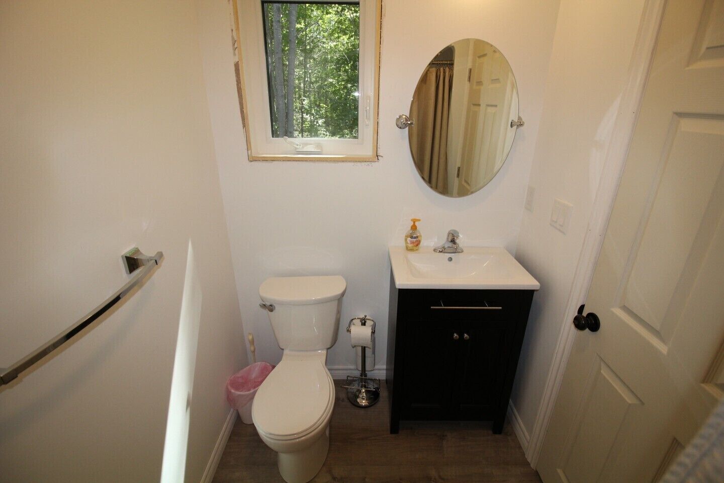 A compact bathroom with a toilet, sink, and mirror.
