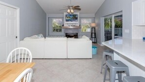 A modern kitchen with a white sofa, a dining table, and a bar area.