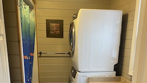 A compact laundry room with a washing machine, dryer, and a small sink. - 4 Bedroom Cottage On Manitoulin Island, Ontario (Providence Bay)