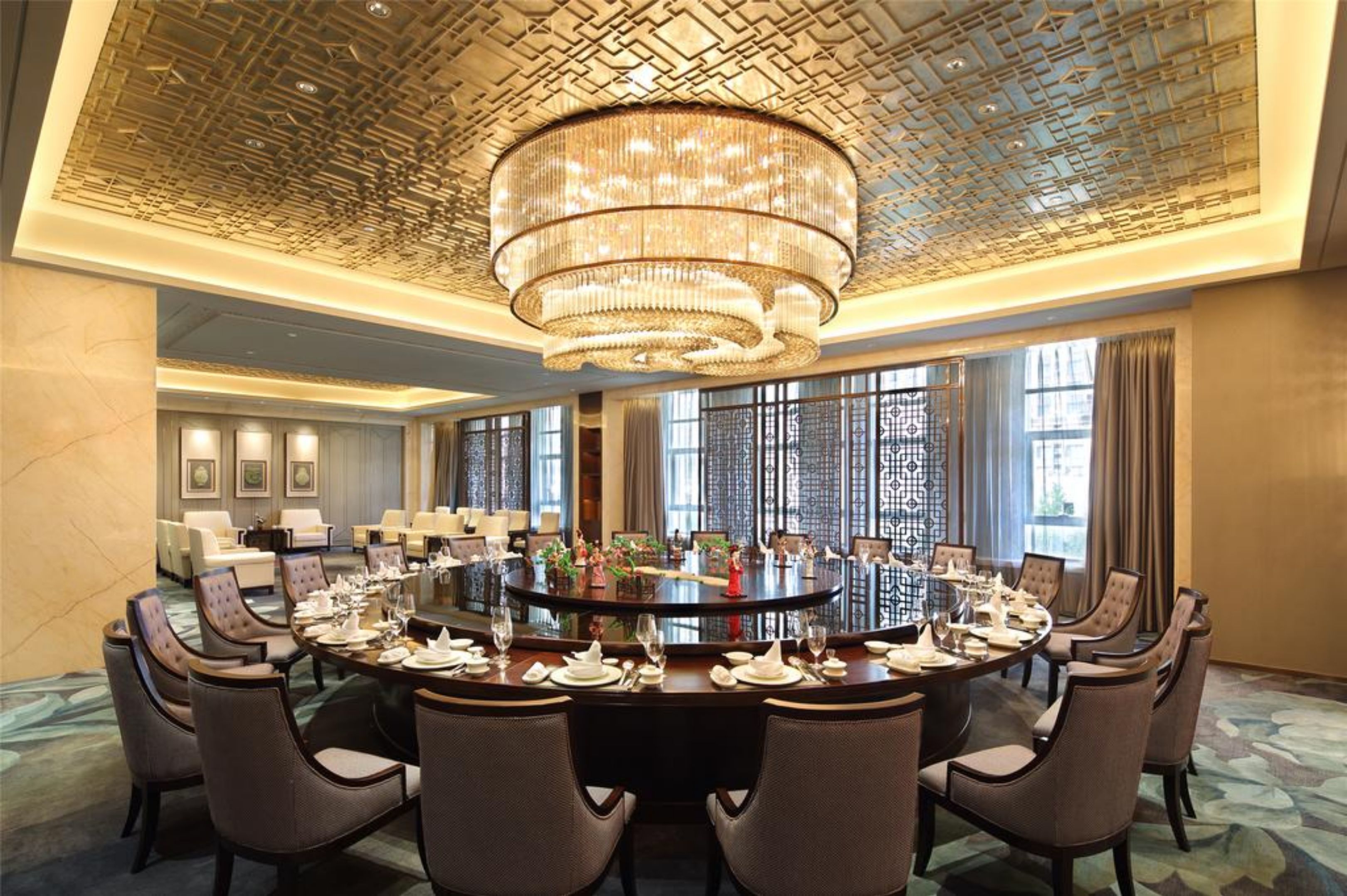 Un salón de conferencias con una mesa redonda, sillas y una araña.