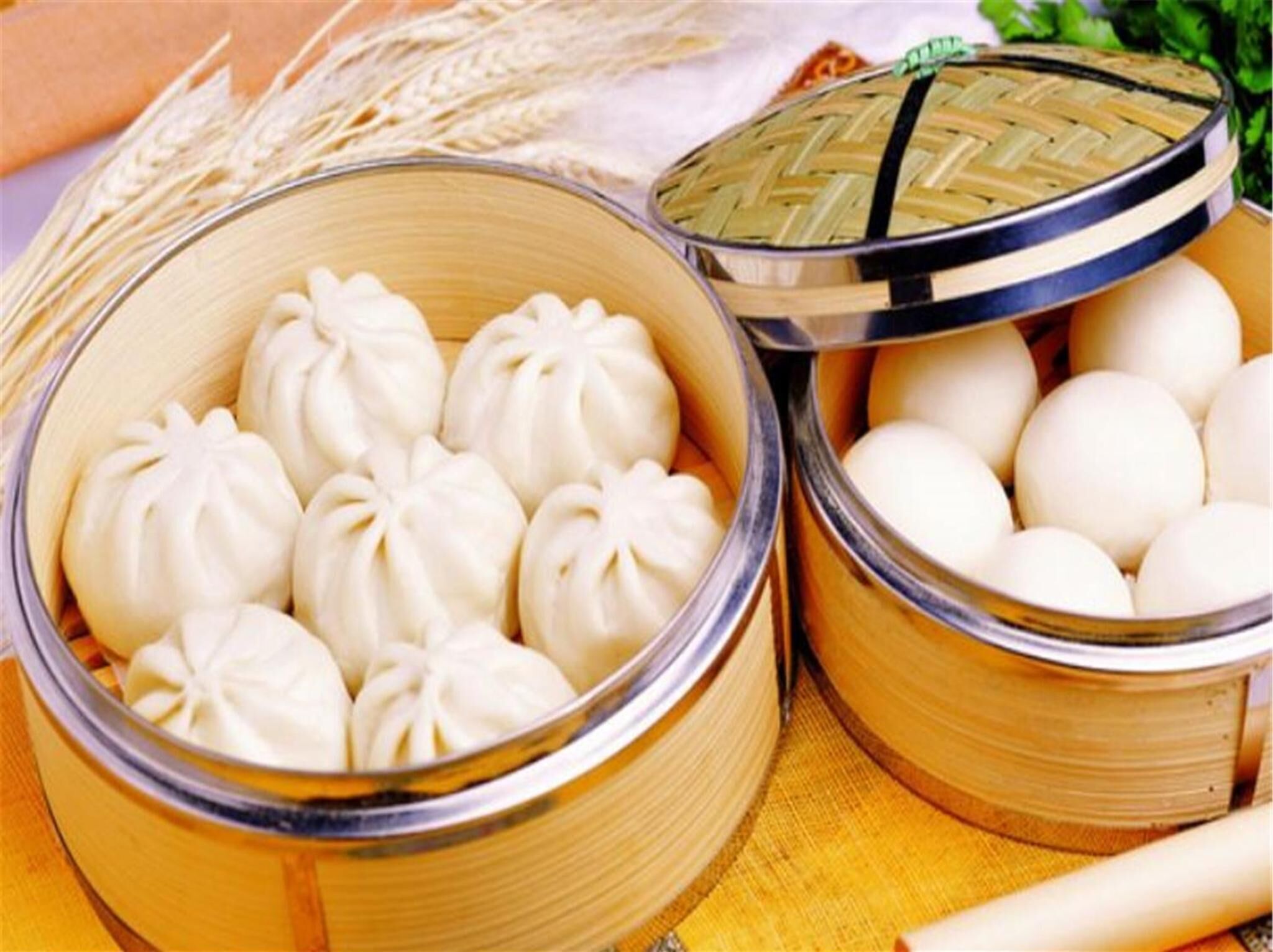 Duas cestas de bambu, uma com dumplings e outra com ovos.