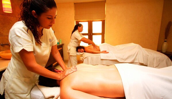 A massage therapy room with two clients receiving treatment.