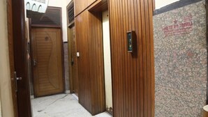 A narrow hallway with wooden doors and a tiled wall. - Hotel Delhi Regency (New Delhi)