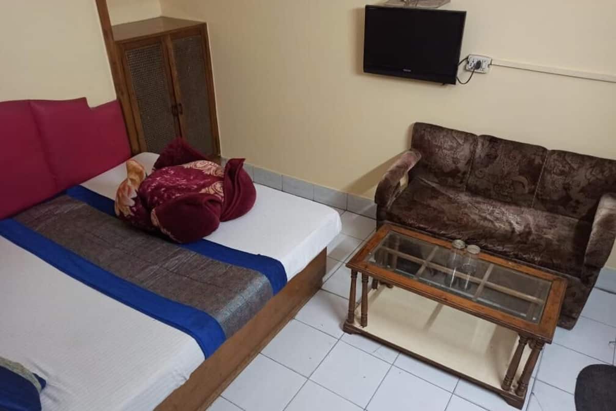 Una habitación con una cama, un sofá y una mesa de centro.
