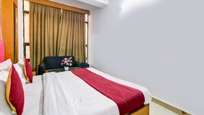 A hotel room with a bed, a chair, a window with curtains, and a ceiling with a skylight. - Hotel Delhi Regency (New Delhi)