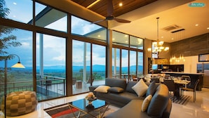 Una sala de estar moderna con un sofá grande, una mesa de centro y vistas al exterior.
