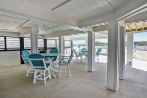 Relax in a serene outdoor space with tables and chairs, offering a view of the water and surrounding landscape.