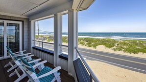 Ein überdachter Balkon mit Blick auf Strand und Meer.