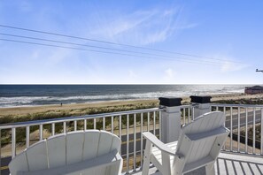 Enjoy the ocean view from this balcony with two Adirondack chairs.