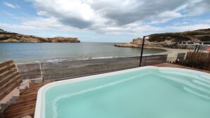 A hot tub with a view of the beach and cliffs. - Beach front apartment with swimming pool ideal for families (Ligaria Beach)