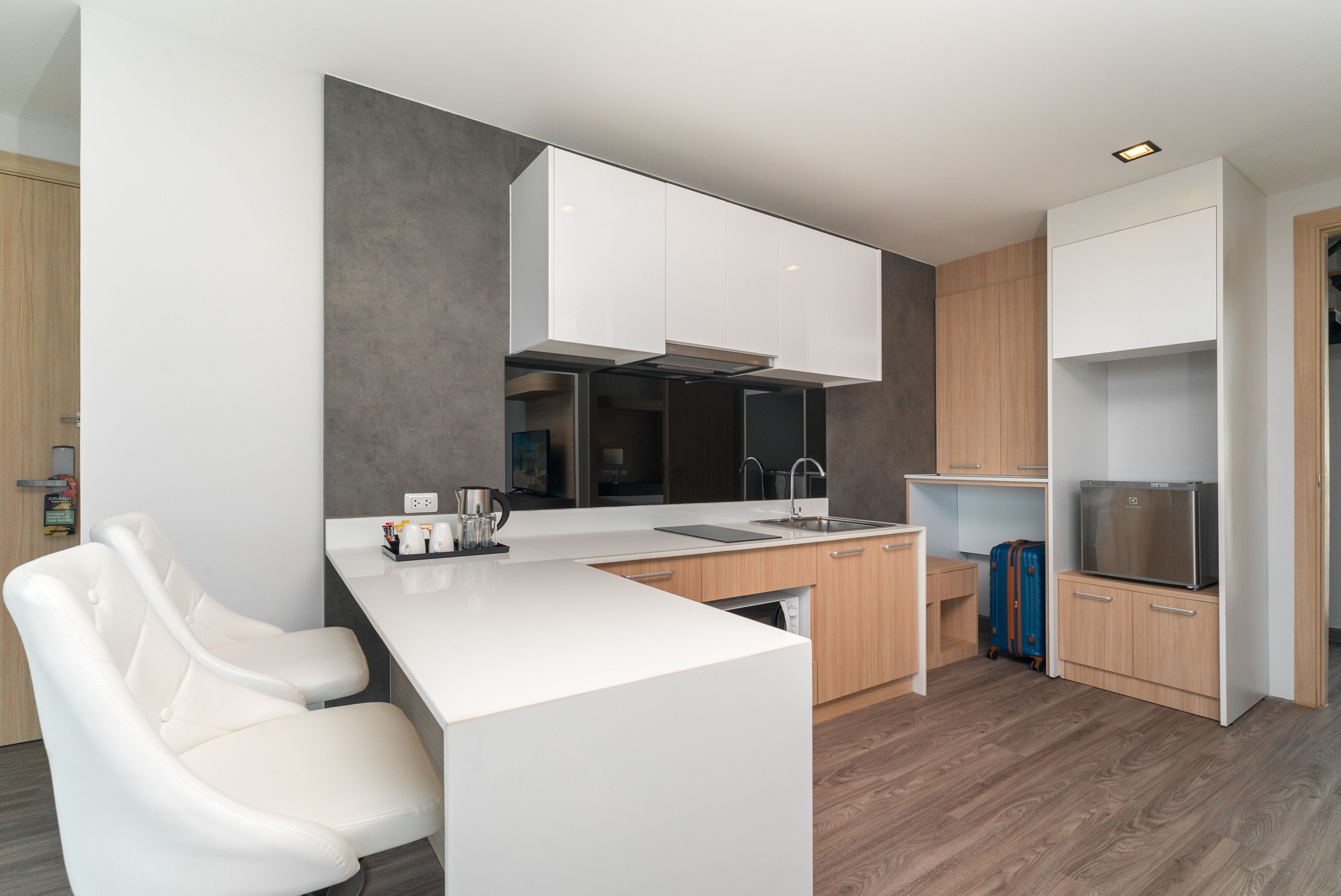 A modern kitchen with white cabinetry, a central island, and a built-in oven.