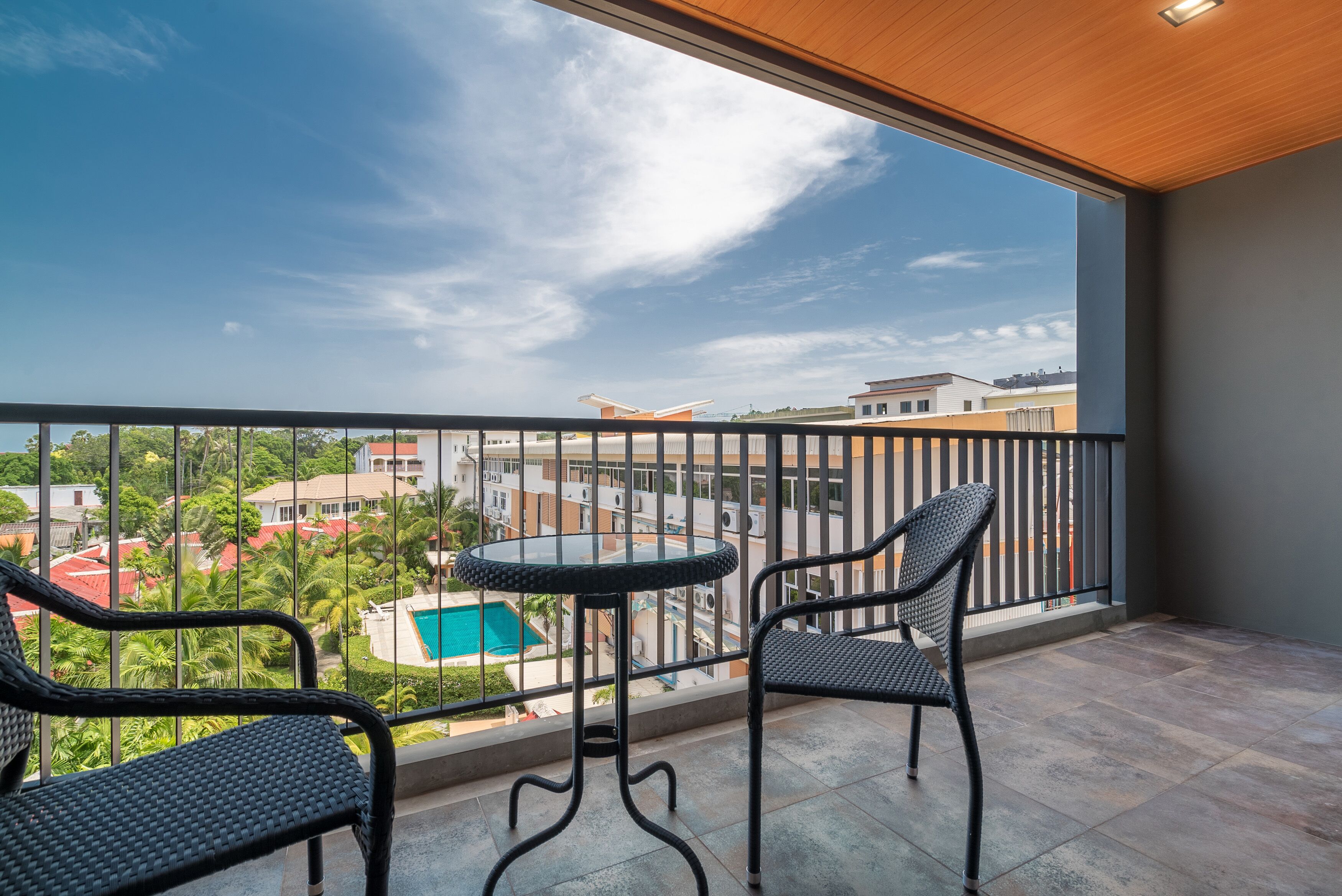 A balcony with a view of a swimming pool and buildings.