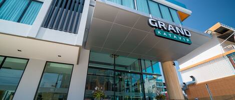 A modern hotel with a prominent sign reading "GRAND KETAVIP."