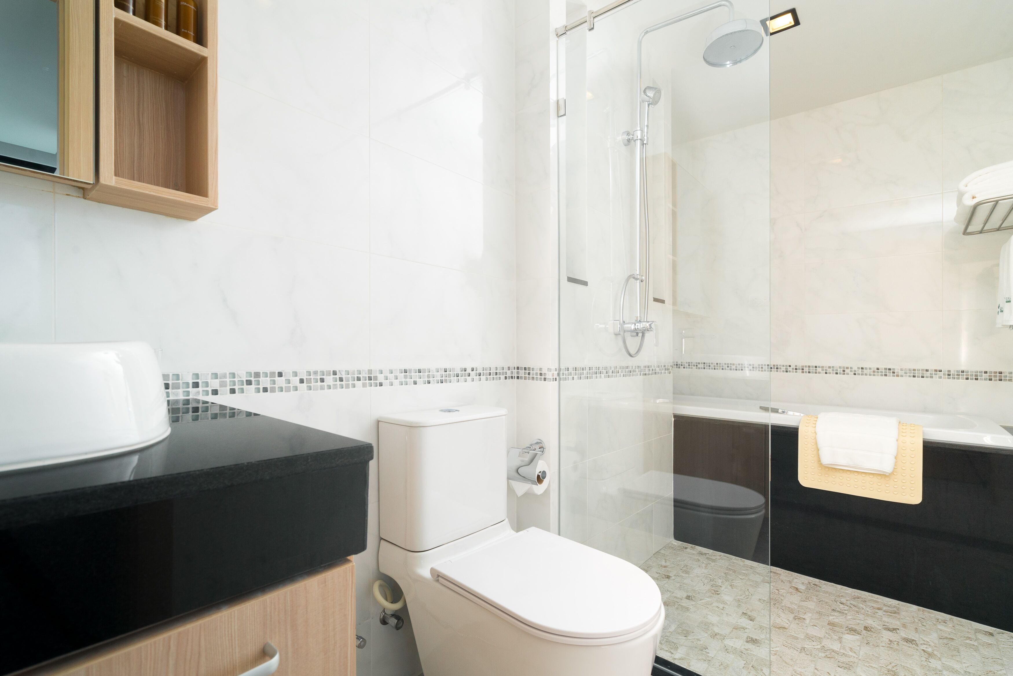 A modern bathroom with a toilet, sink, and shower.