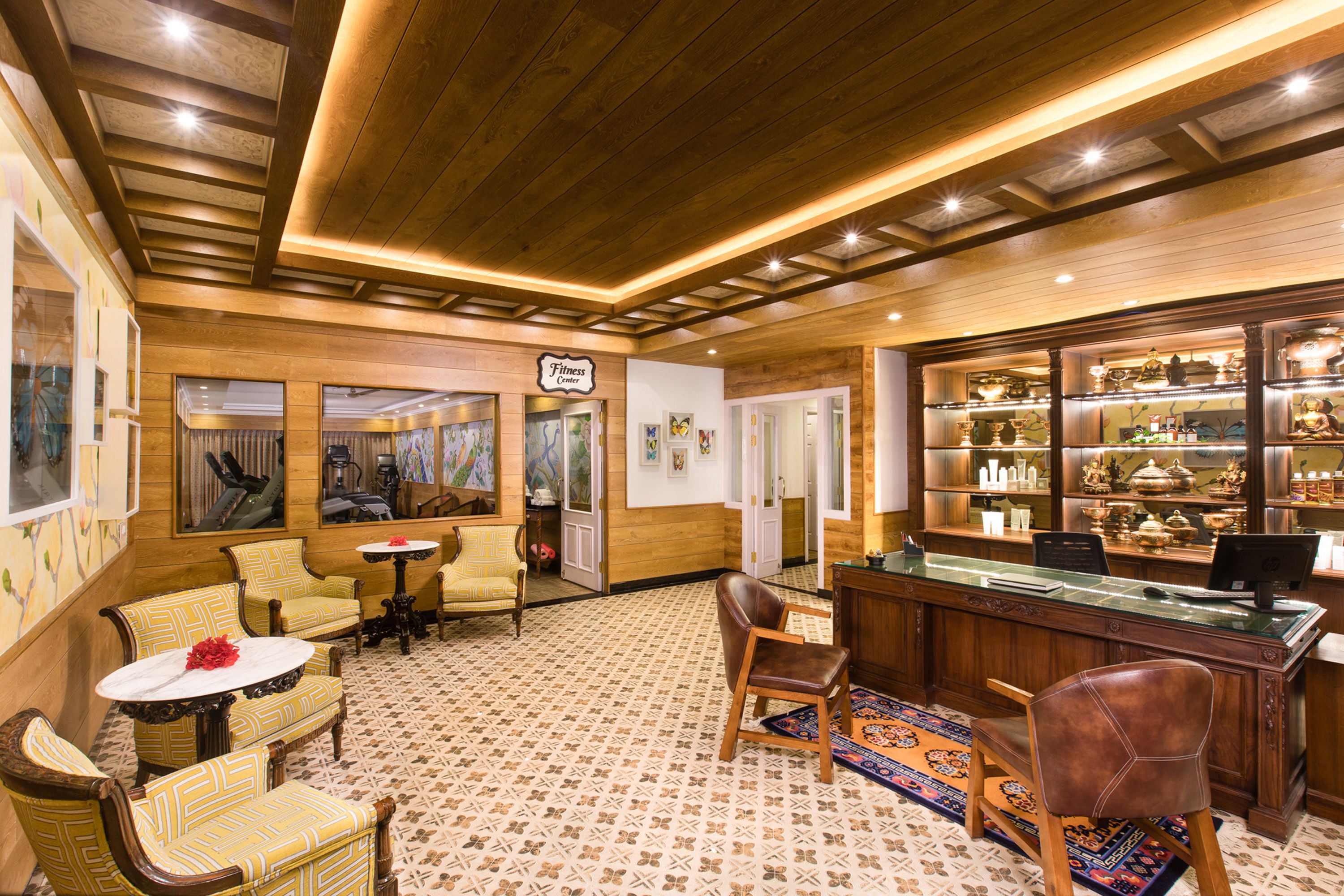 A hotel lobby with wooden paneling, a reception desk, and a display of local crafts.