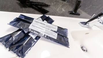 個別の浴槽とシャワー、バスアメニティ (無料)、ヘアドライヤー、スリッパ