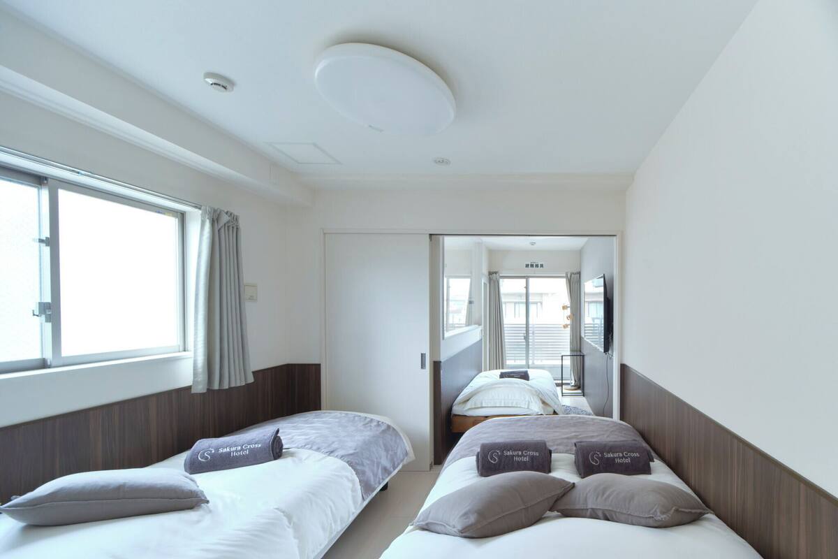 Ein Hotelzimmer mit zwei Betten, einem großen Fenster und Blick nach außen.