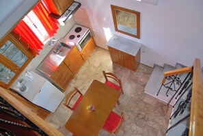 A compact kitchen with a dining area, a stove, a sink, and a small refrigerator. - houdis House - Family House with Garden and Pool (Paralio Astros)