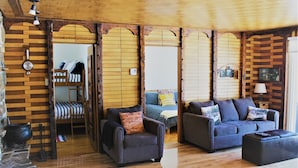 A cozy room with a wooden ceiling, a sofa set, a chair, and a small table. A ladder is leaning against the wall, and a clock is visible on the wall. - Lakefront Chalet Mont Tremblant - Spectacular view - WIFI (CITQ 294661) (Lac-Supérieur)