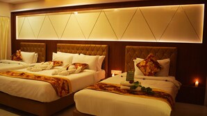 A hotel room with two beds, each with a tufted headboard, white bedding, and decorative pillows. - Hotel New Majestic (Ajmer)