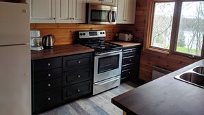 Eine Küche mit Holzsäcken, einer Mikrowelle, einem Herd und einem Toaster.