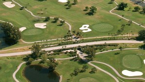 An aerial view of a golf course with sand bunkers, water hazards, and a bridge connecting different areas. - Sarasota Downtown Apartment!!! (Sarasota)