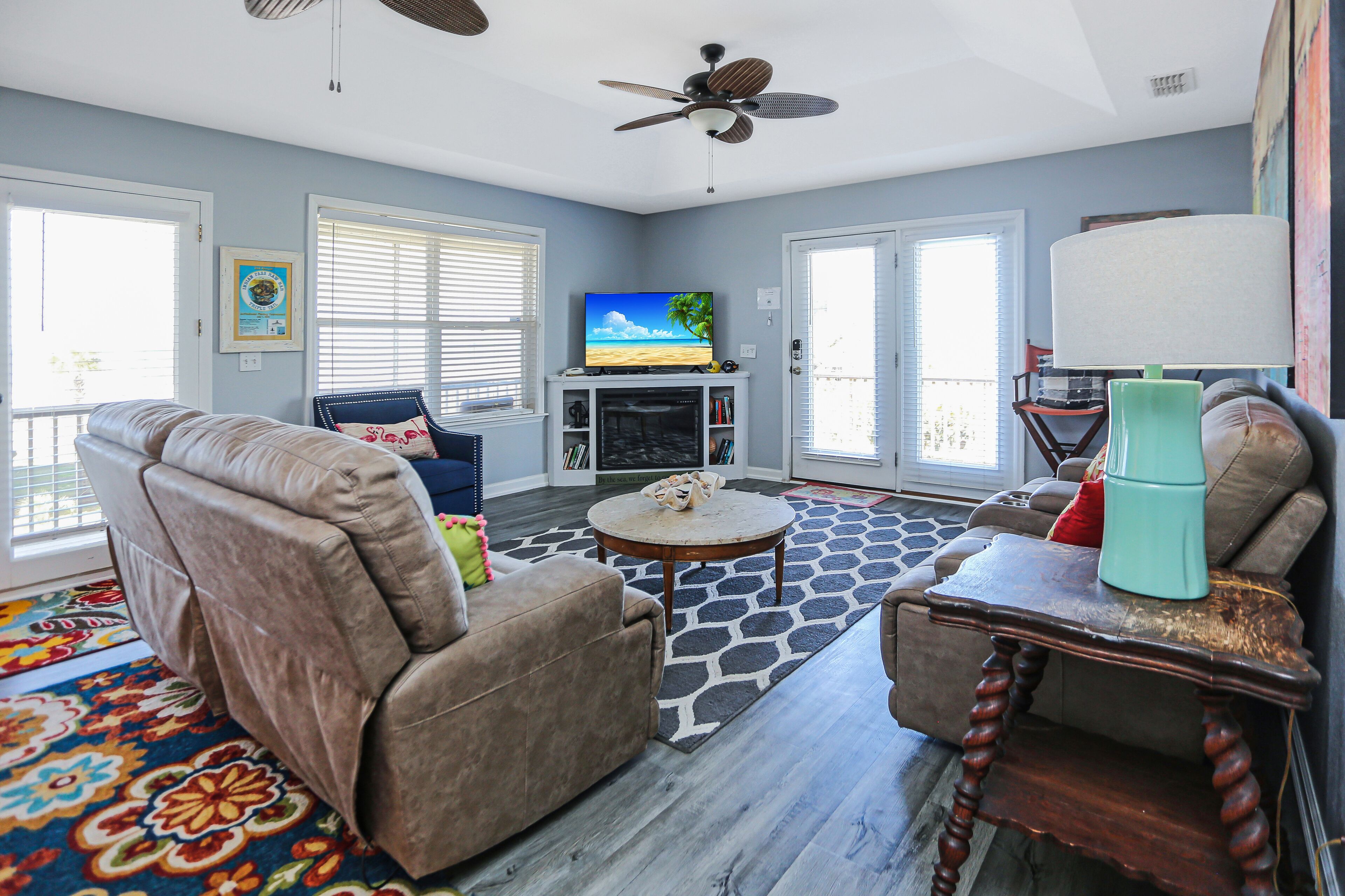 Een woonkamer met een bank, salontafel en een televisie op een dressoir.