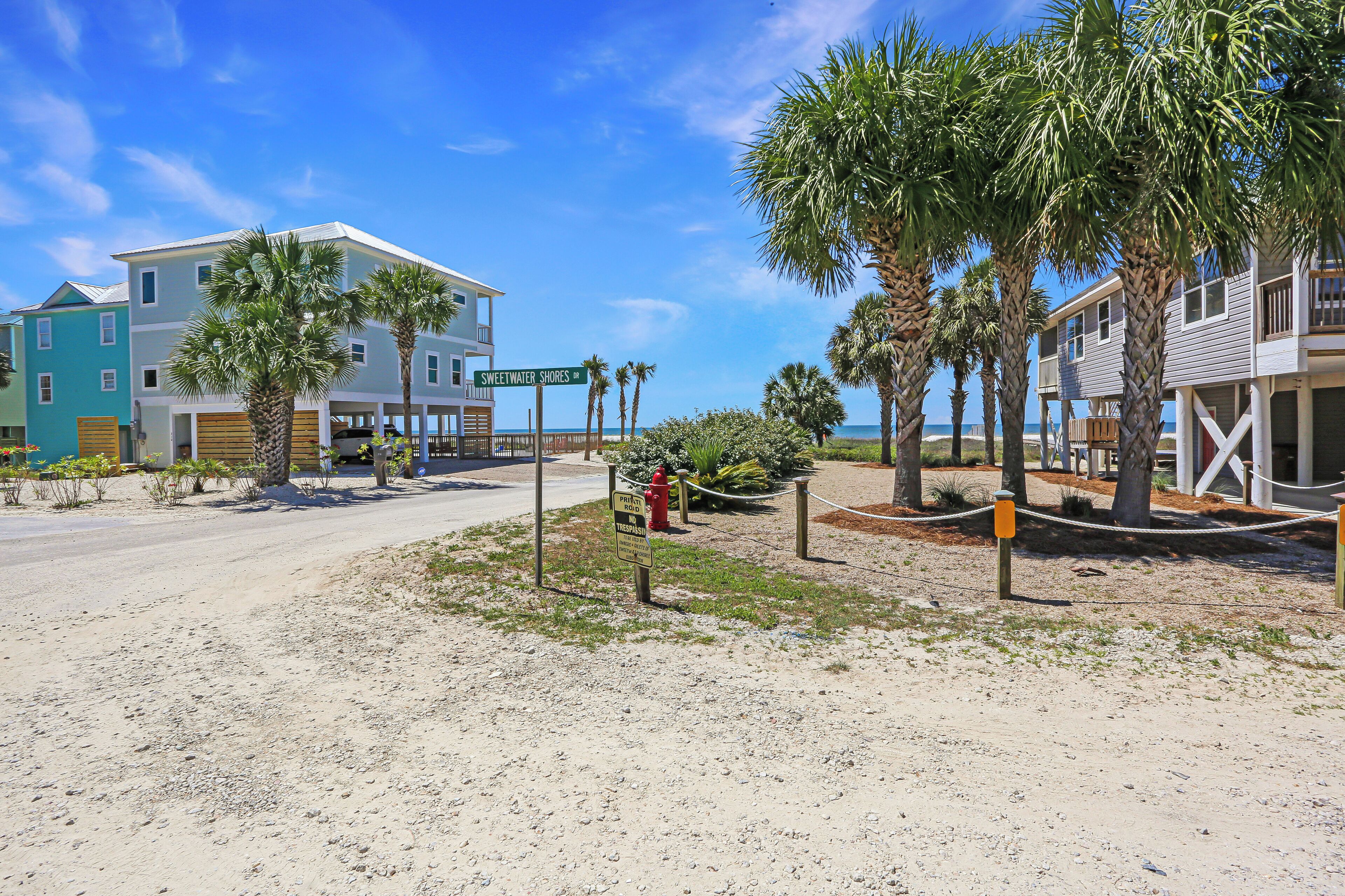 A beachfront property with a sign reading "Sweetwater Shores."
