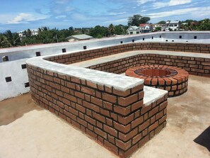 A rooftop with a circular brick structure and a concrete floor.