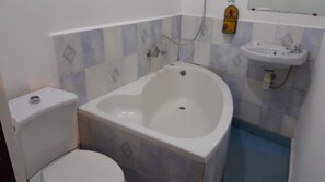 A bathroom with a bathtub, toilet, and sink.