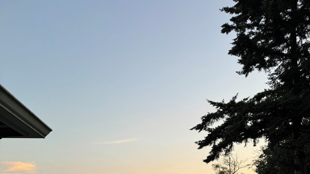 A deck with a round table and chairs, overlooking a body of water during sunset. - Upper Level with a view close to Boeing (everett)