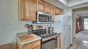 A kitchen with wooden cabinets, a stainless steel microwave, a refrigerator, and an oven. - Green Valley Townhome w/ Patio & Resort Amenities (Green Valley)