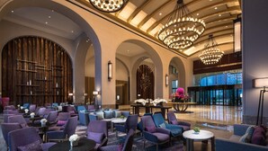 A spacious lobby with multiple seating areas, large chandeliers, and a modern architectural design. - Doubletree by Hilton Qingdao Oriental Movie Metrop (Qingdao)