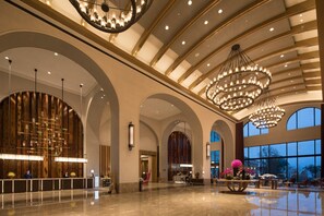 Un lobby espacioso con techos altos, amplias ventanas de arco y elegantes candelabros.