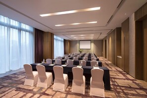A conference room with a long table, chairs, and a projector screen. - Doubletree by Hilton Qingdao Oriental Movie Metrop (Qingdao)