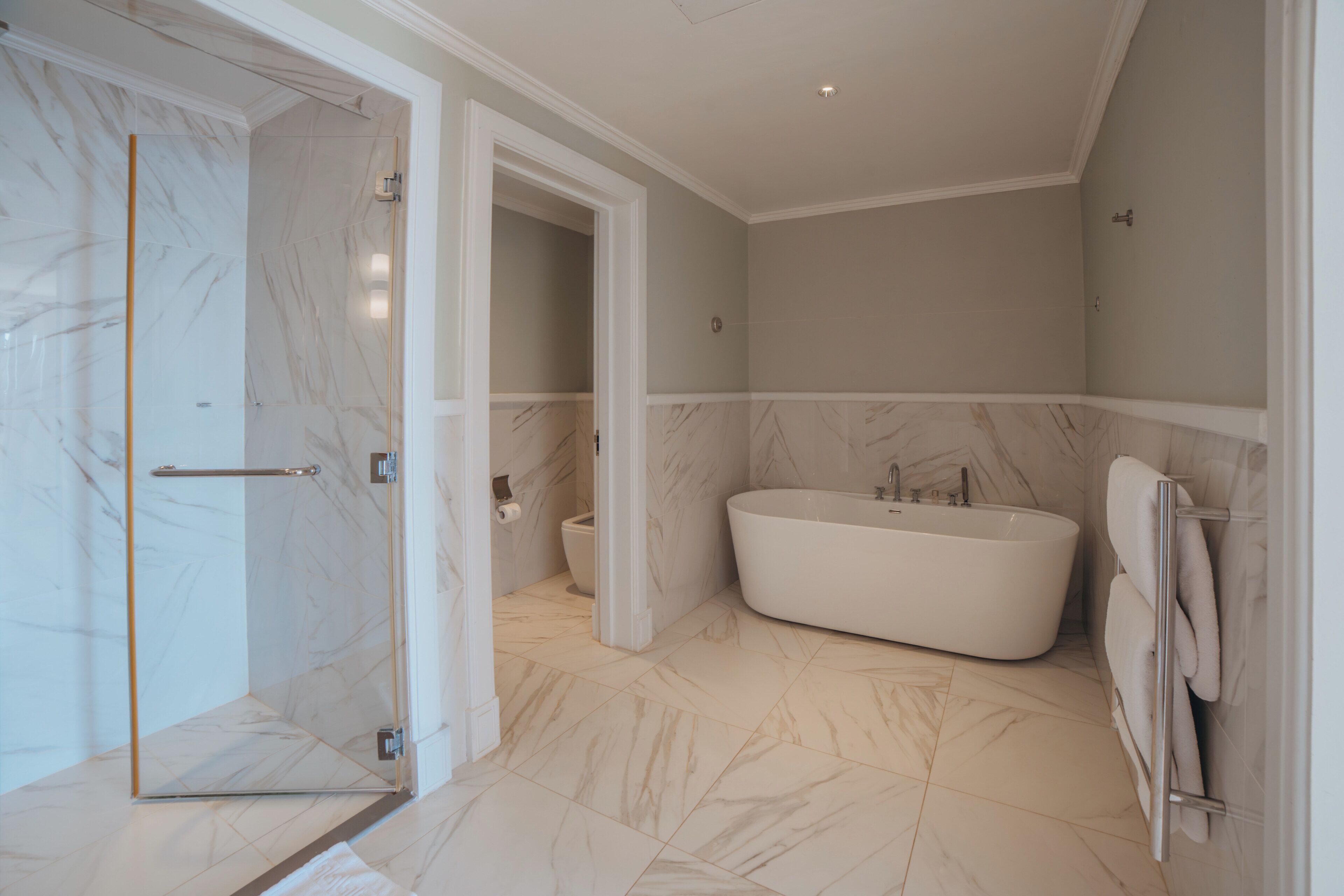 Une salle de bain moderne avec une douche à parois de verre, une baignoire sur pieds et des toilettes.