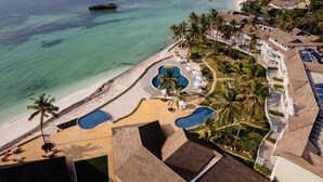 Un resort con playa, piscinas y palmeras.