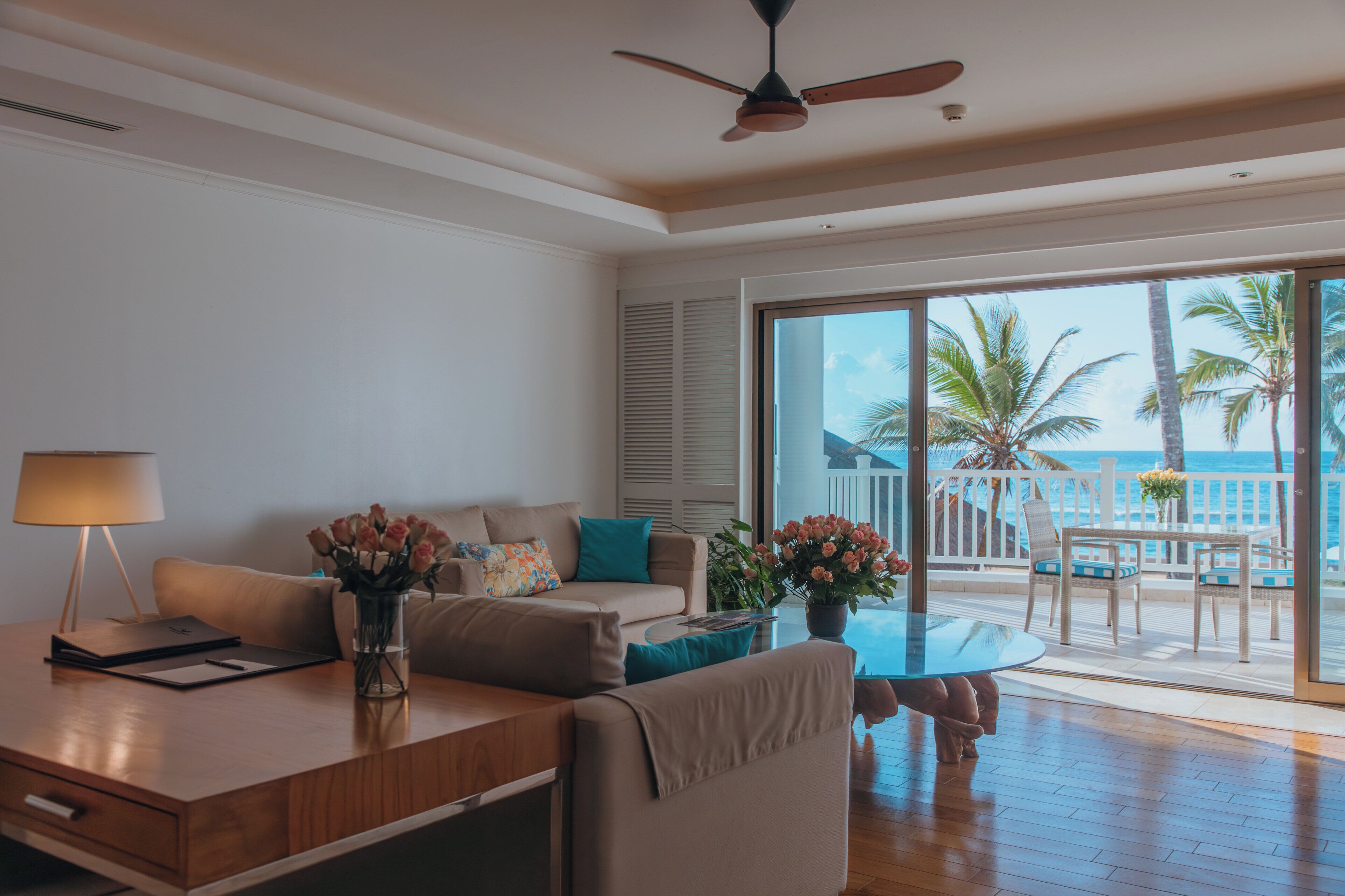 A modern living room with a sofa, coffee table, and a view of the ocean.