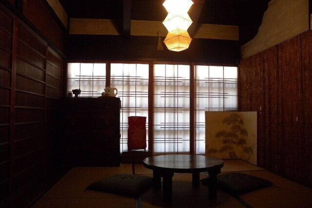 Een traditionele Japanse kamer met tatami vloeren, een lage tafel, kussens en een schuifdeur.