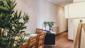 Un comedor con una mesa de madera, sillas y una planta en maceta.