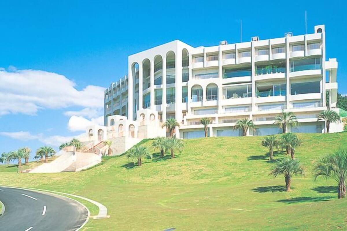 A multi-story hotel with a modern architectural design, featuring balconies and a prominent entrance.