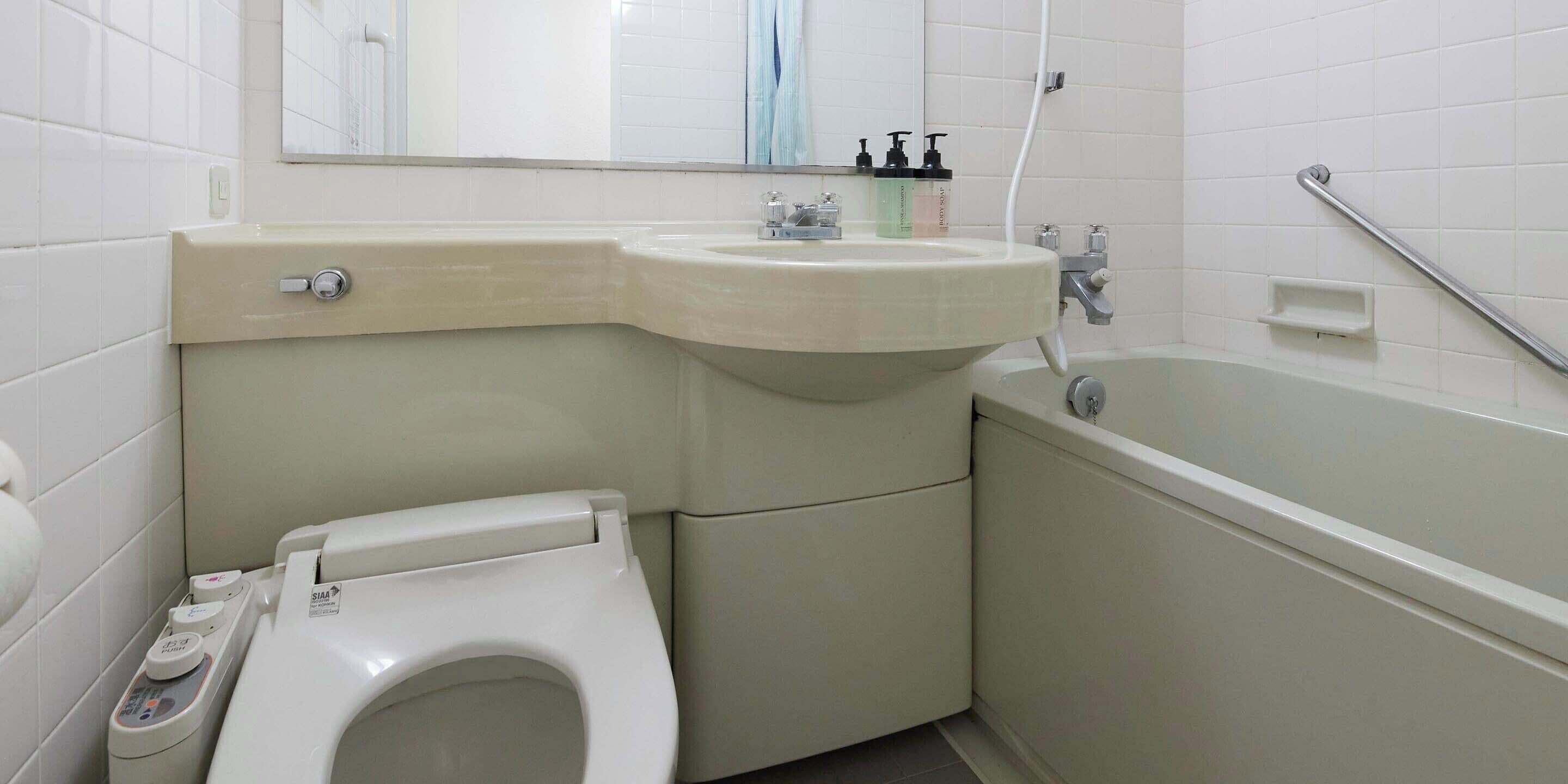 Une salle de bain avec des toilettes, un lavabo et une baignoire.