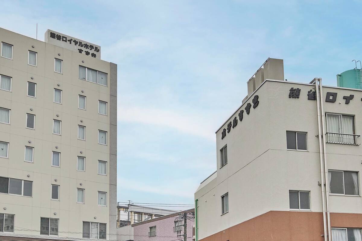 A multi-story building with a flat facade, multiple windows, and a sign indicating it is a hotel.