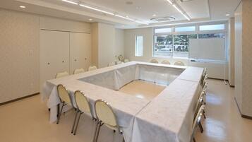 A conference room with a long table, chairs, and a whiteboard.